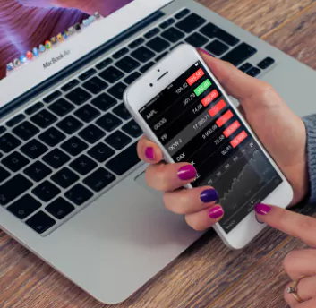 Girl holding mobile phone with finance system dashboard screen
