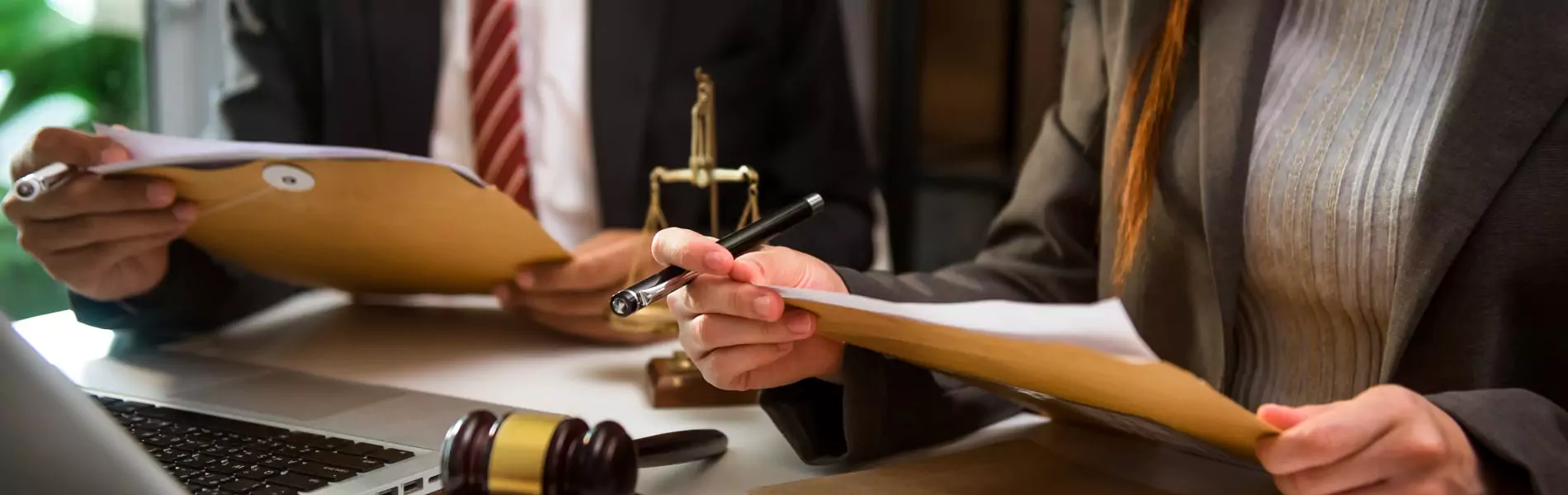 Two people have legal papers and pen on hand