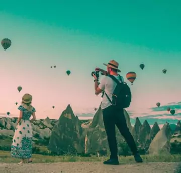 A man taking picture of girl from back at beautiful location